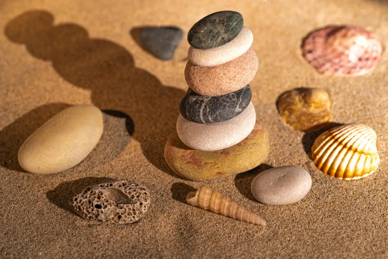 LernAnker Trier – Steine und Muscheln am Strand symbolisieren Ruhe und Balance beim Lernen